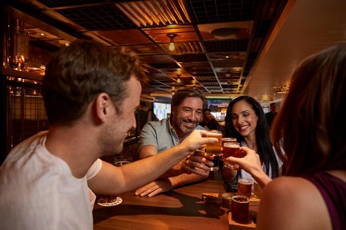 a group of friends enjoying beer at guy’s pig and anchor barbeque smokehouse and brewhouse