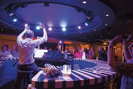 audience raises hand with piano player