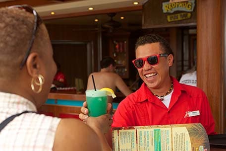 bar waiter delivers fruity drink at redfrog rum bar